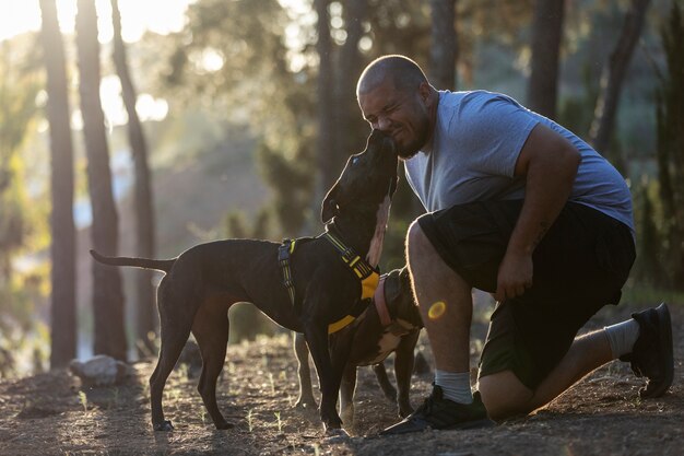 Man outdoors dog training with two dogs hi2y